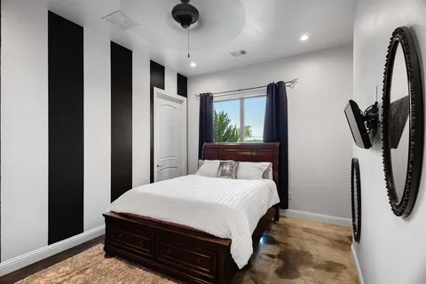 a bedroom with a bed a television and a large window