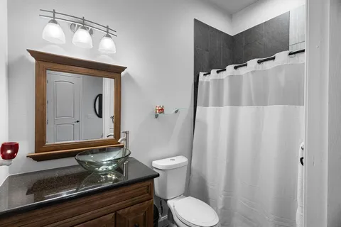 a bathroom with a granite countertop sink and a mirror
