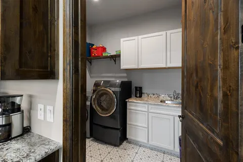 a utility room with sink dryer and washer