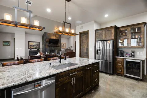 a kitchen with stainless steel appliances granite countertop a sink a stove and a refrigerator
