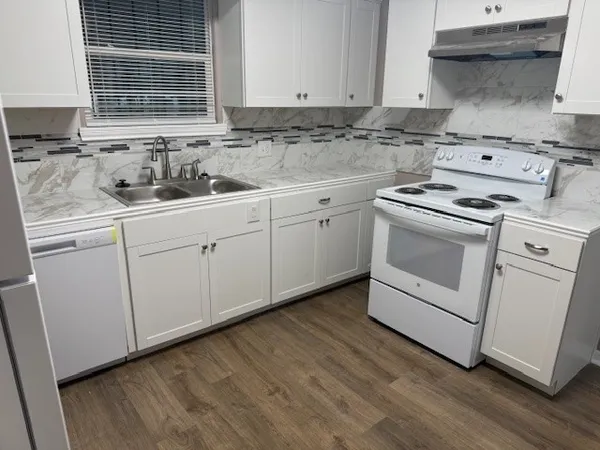 a kitchen with sink a stove and cabinets