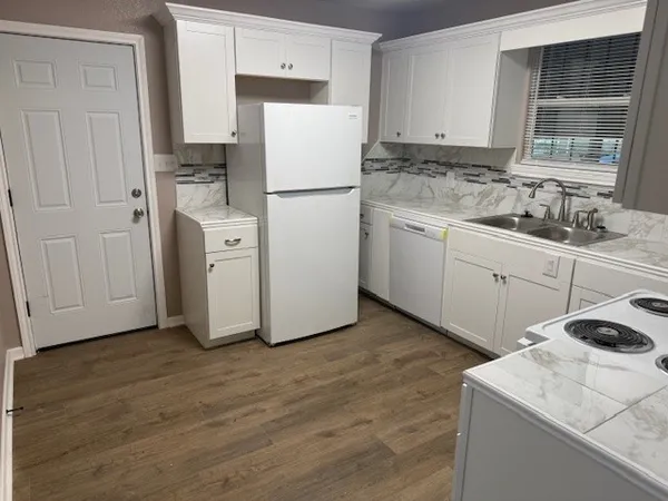 a kitchen with a sink a refrigerator and cabinets