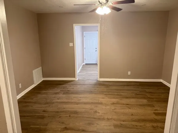 a view of an empty room with wooden floor