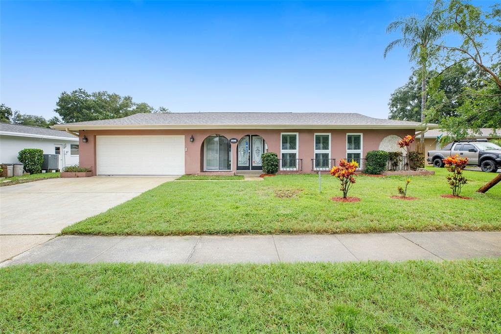 a front view of a house with a yard and trees