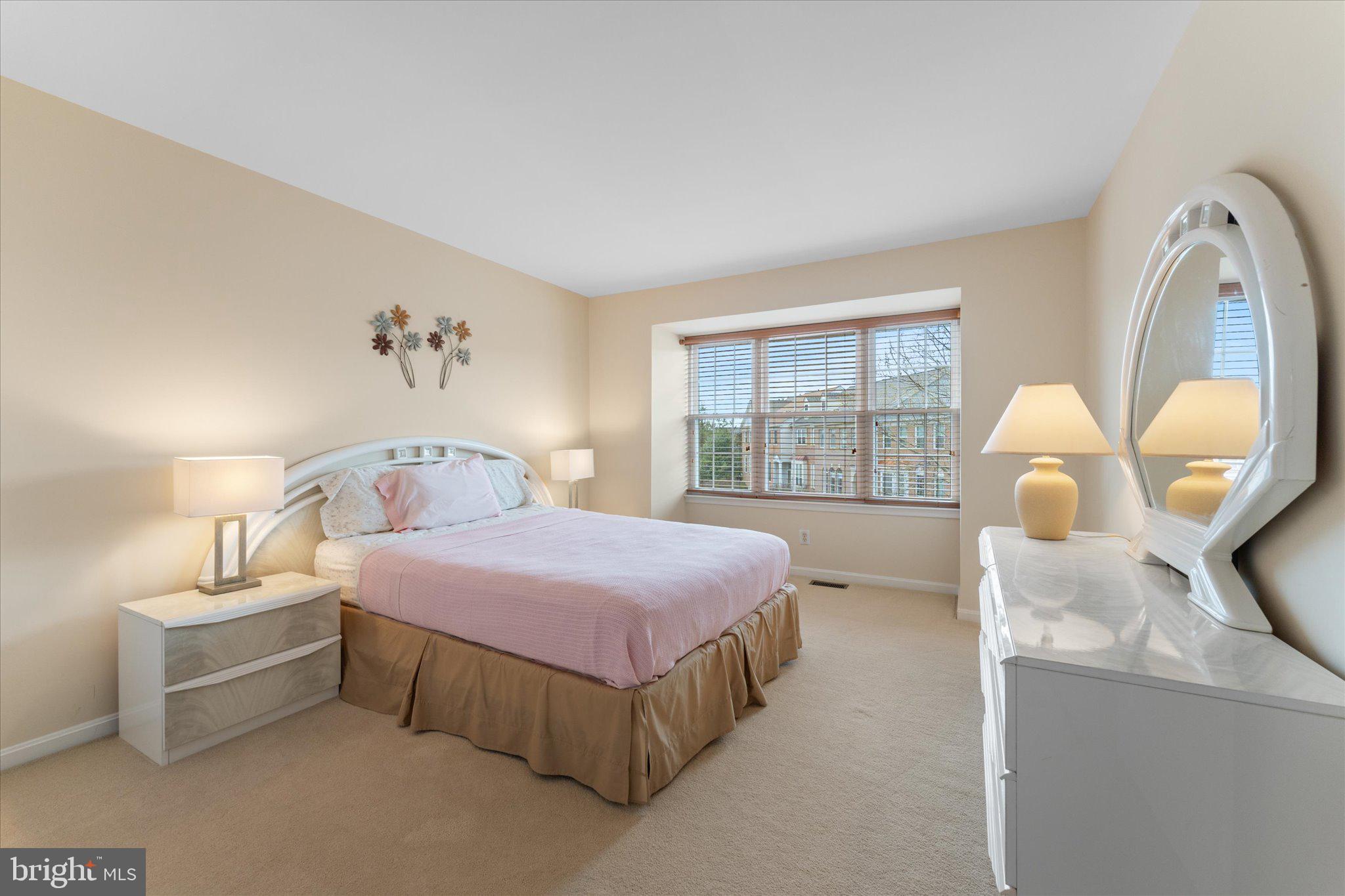 20900 Trinity Square Sterling, VA 20165 - Photo 14 of 46 a spacious bedroom with a bed a table and large window