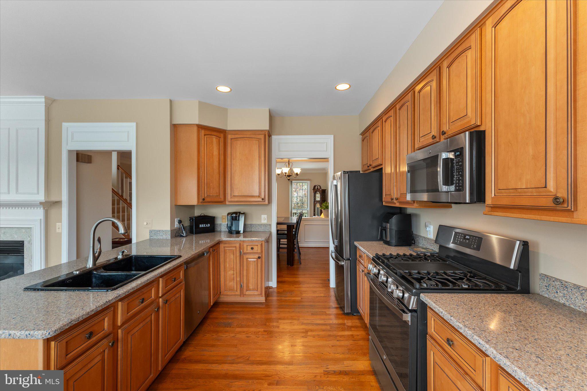 20900 Trinity Square Sterling, VA 20165 - Photo 30 of 46 a kitchen with stainless steel appliances granite countertop a stove a sink and a microwave
