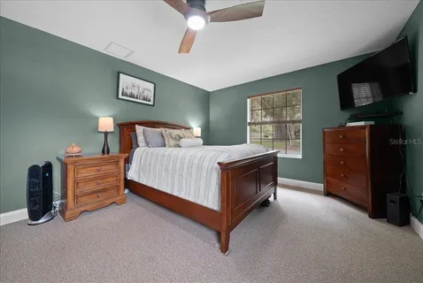 a bedroom with a bed and a tv on dresser