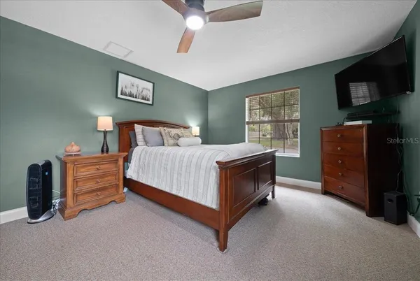 a bedroom with a bed and a tv on dresser