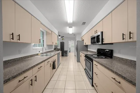 a large kitchen with stainless steel appliances granite countertop a sink a stove top oven and a granite counter tops