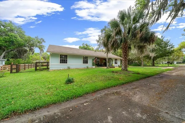 a front view of a house with a yard and trees