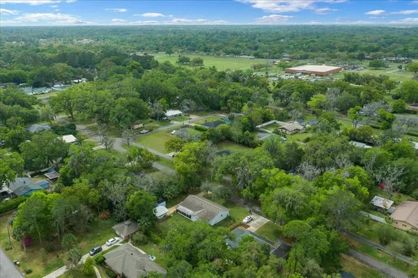 an aerial view of residential houses with outdoor space and trees
