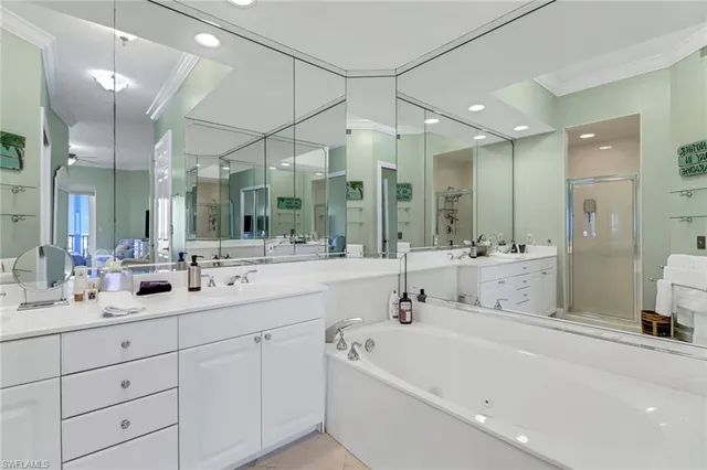 a bathroom with a double vanity sink mirror and bathtub