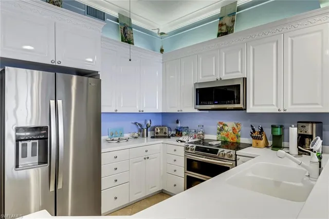 a kitchen with stainless steel appliances white cabinets and a refrigerator