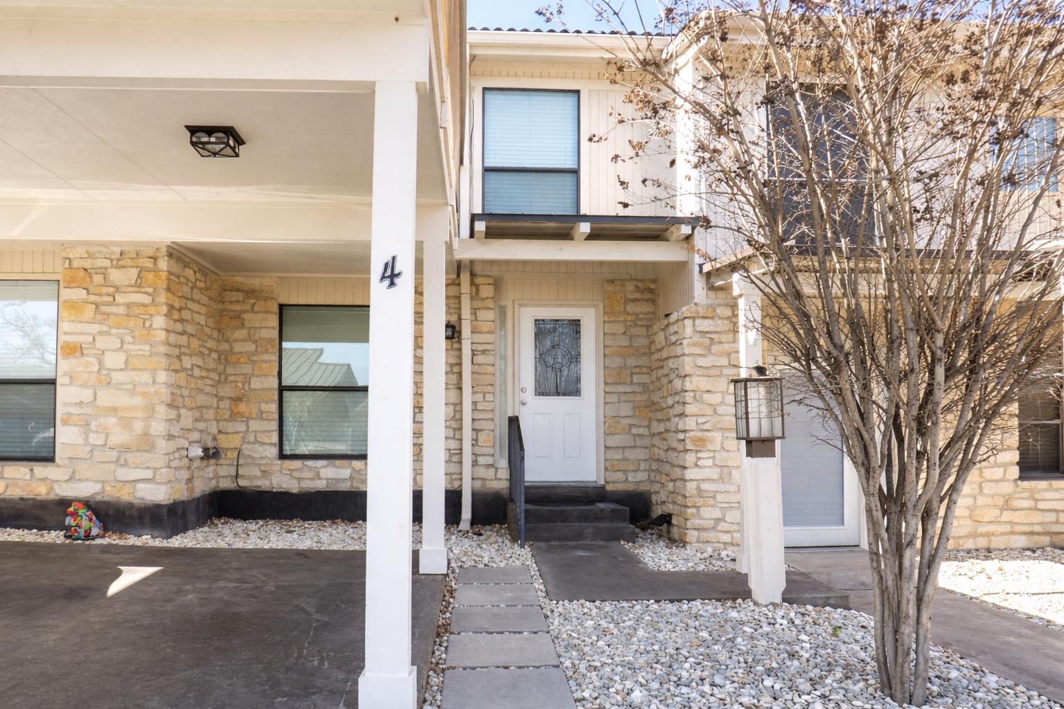 a front view of a house with a tree