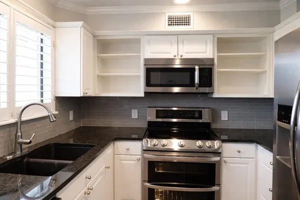 a kitchen with stainless steel appliances a stove a sink and a microwave