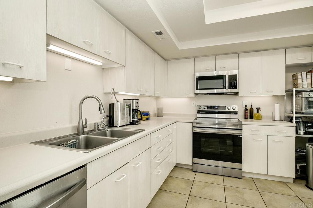7585 Eads Avenue, Unit C La Jolla, CA 92037 - Photo 13 of 29 a kitchen with stainless steel appliances granite countertop a sink and cabinets
