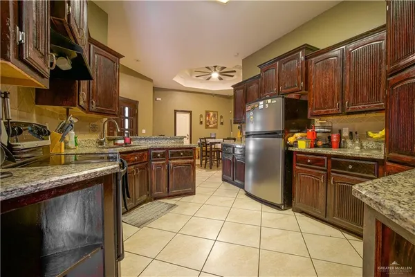 a kitchen with stainless steel appliances granite countertop a stove refrigerator sink and cabinets