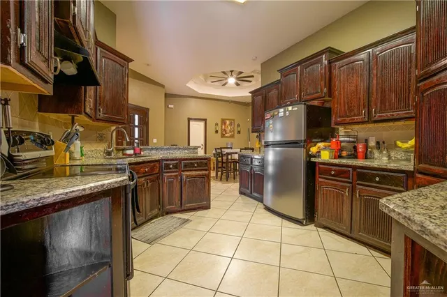 a kitchen with stainless steel appliances granite countertop a stove refrigerator sink and cabinets