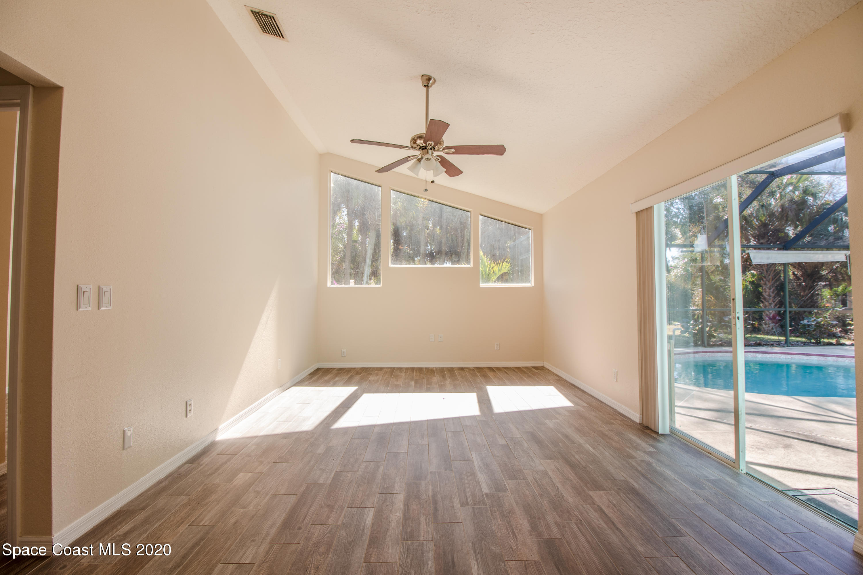 5345 Cangro Street Cocoa, FL 32926 - Photo 12 of 28 an empty room with wooden floor fan and windows