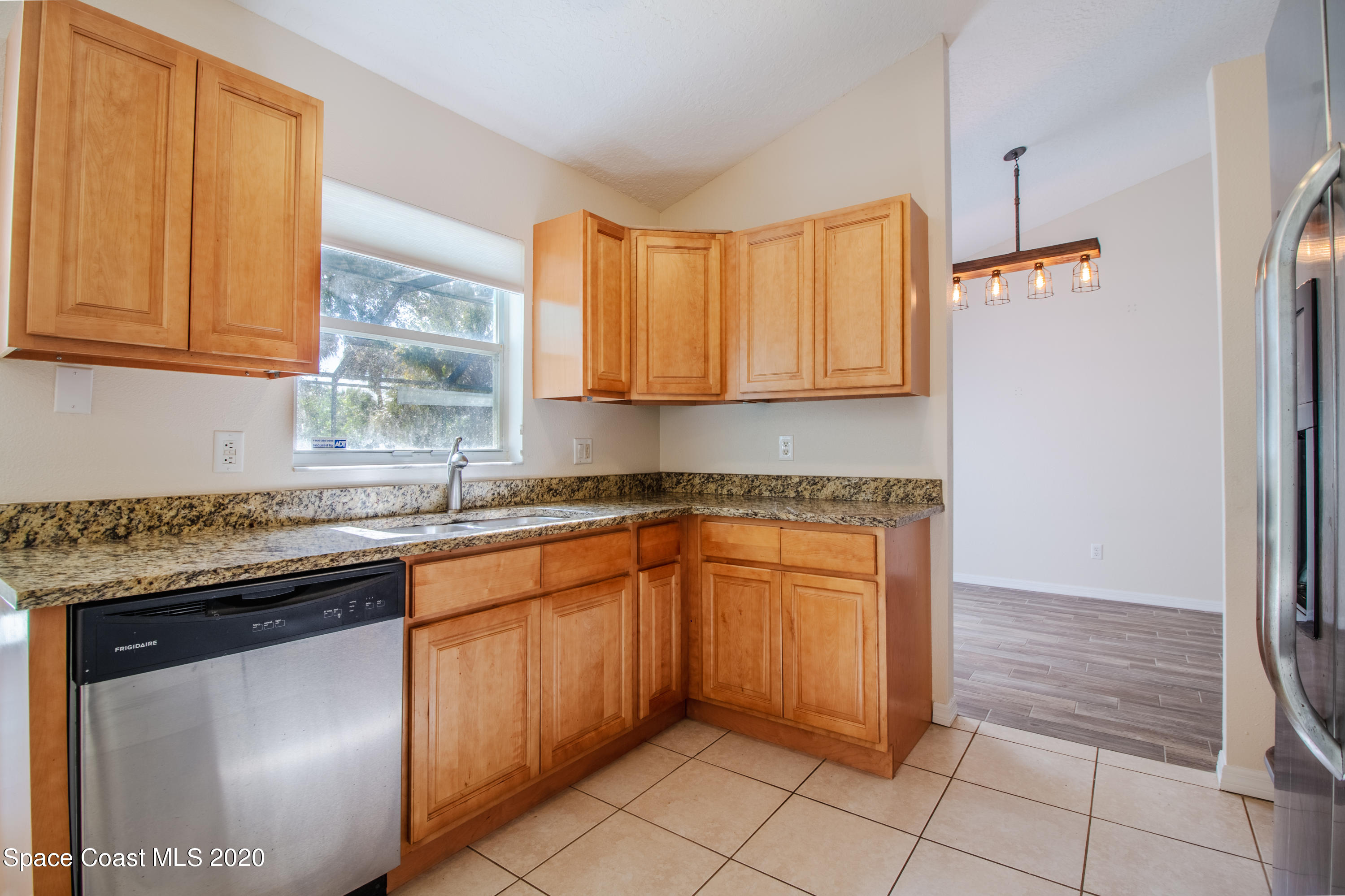 5345 Cangro Street Cocoa, FL 32926 - Photo 13 of 28 a kitchen with stainless steel appliances granite countertop a sink and a refrigerator