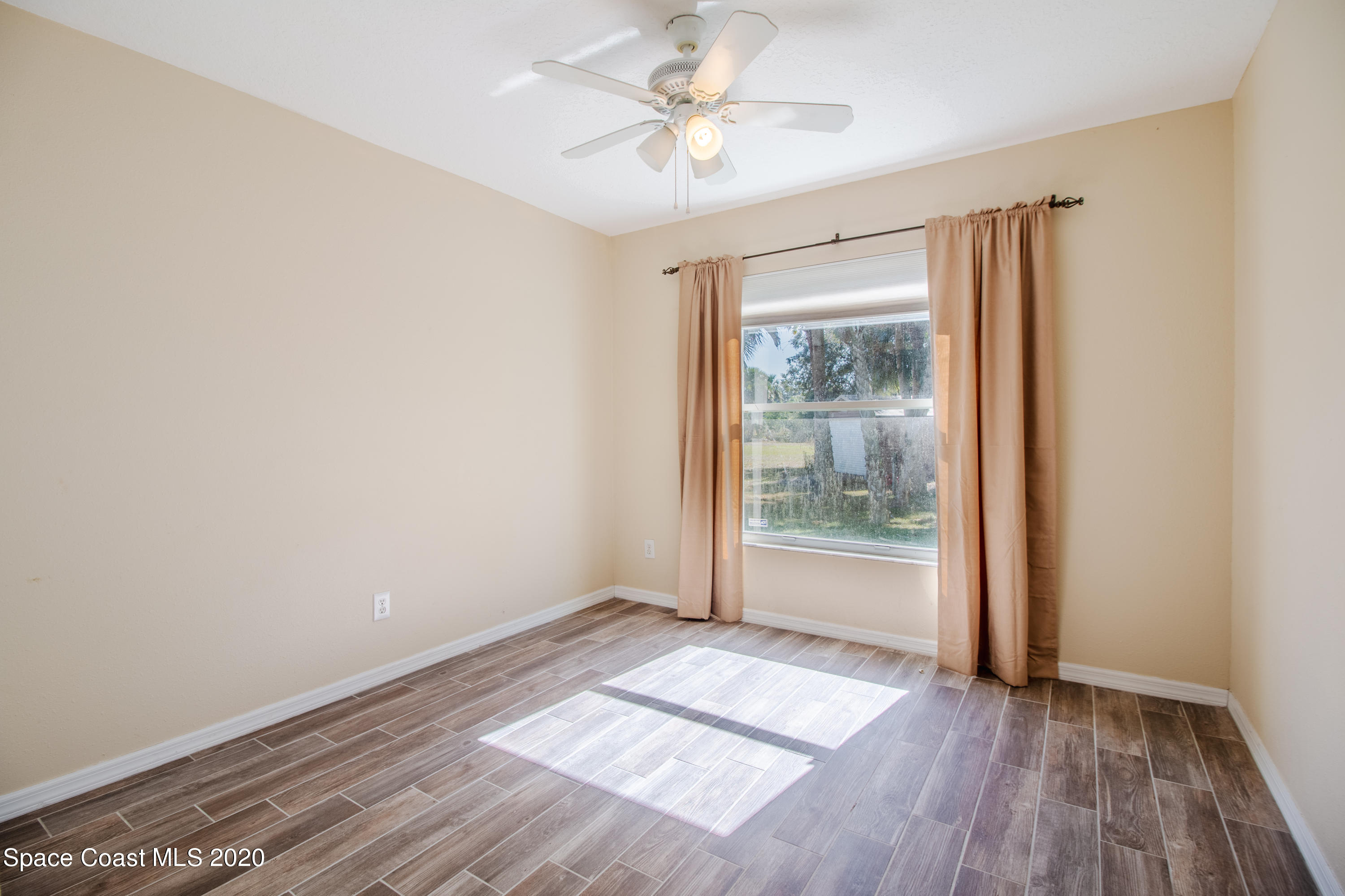 5345 Cangro Street Cocoa, FL 32926 - Photo 16 of 28 an empty room with wooden floor and windows