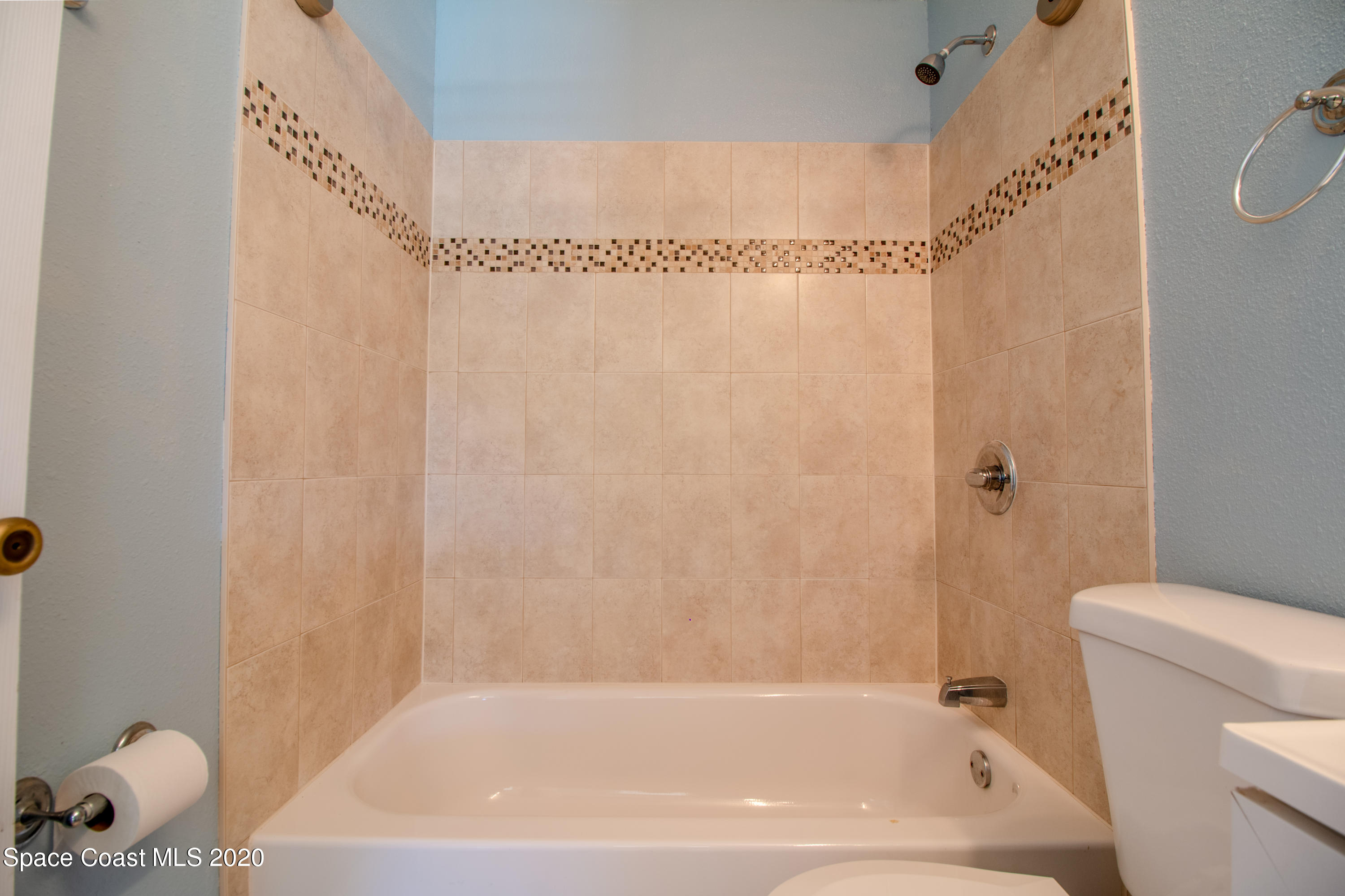 5345 Cangro Street Cocoa, FL 32926 - Photo 19 of 28 a bath tub sitting next to a white toilet and sink