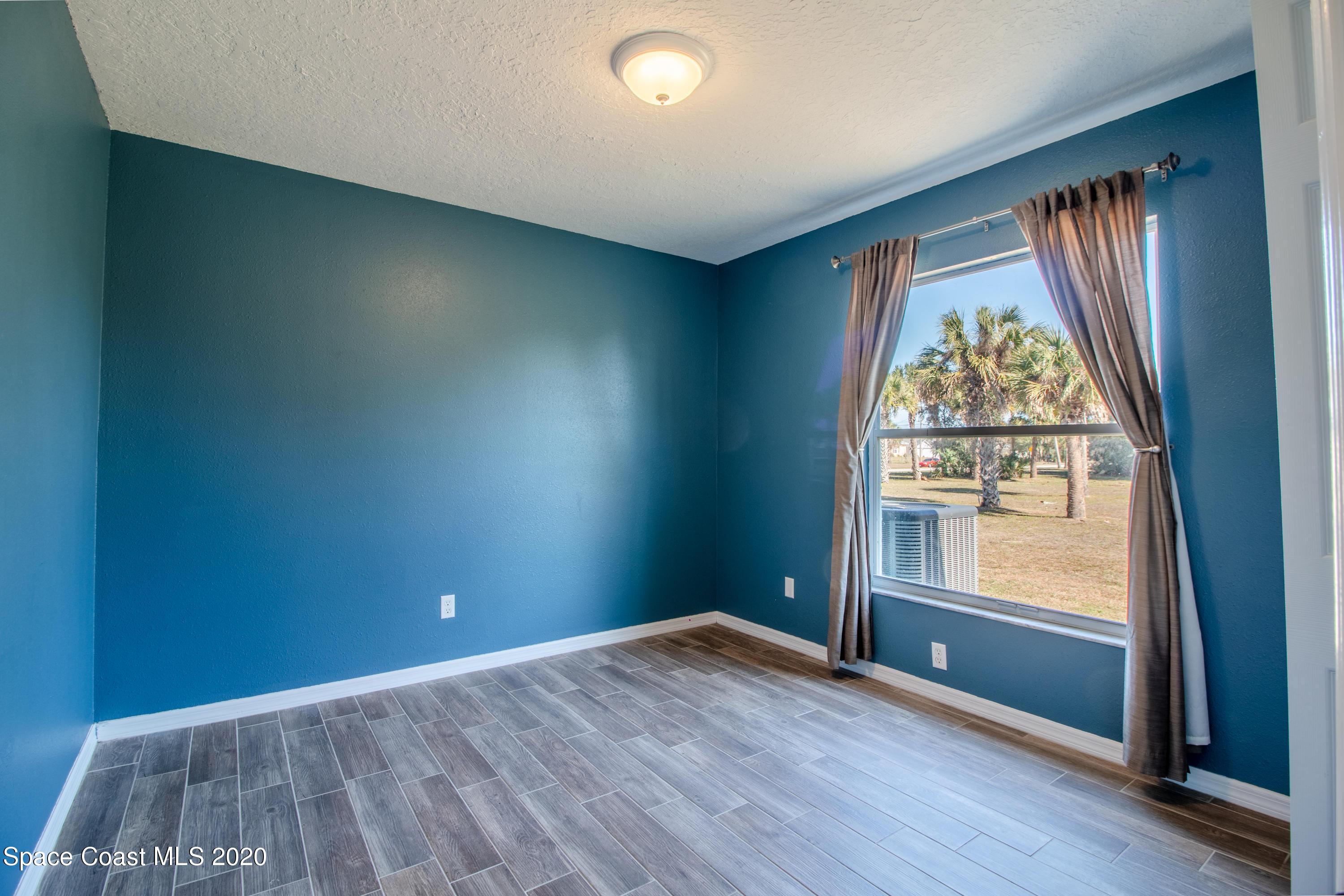 5345 Cangro Street Cocoa, FL 32926 - Photo 20 of 28 an empty room with wooden floor and windows