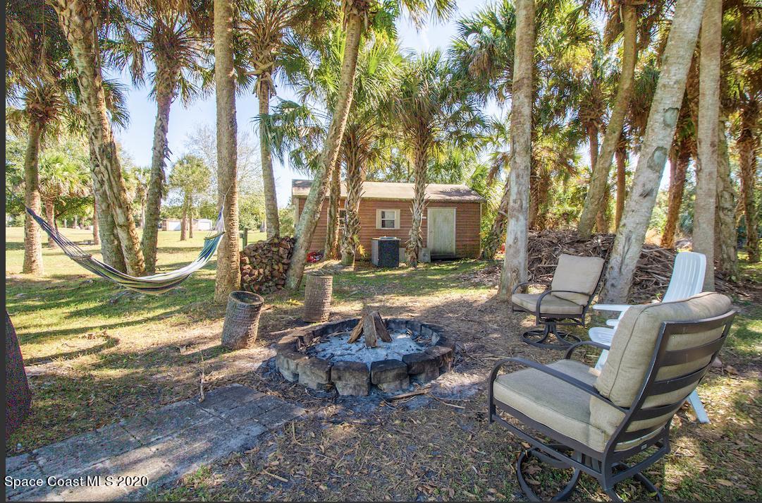 5345 Cangro Street Cocoa, FL 32926 - Photo 3 of 28 a view of a backyard with table and chairs couches and a large tree
