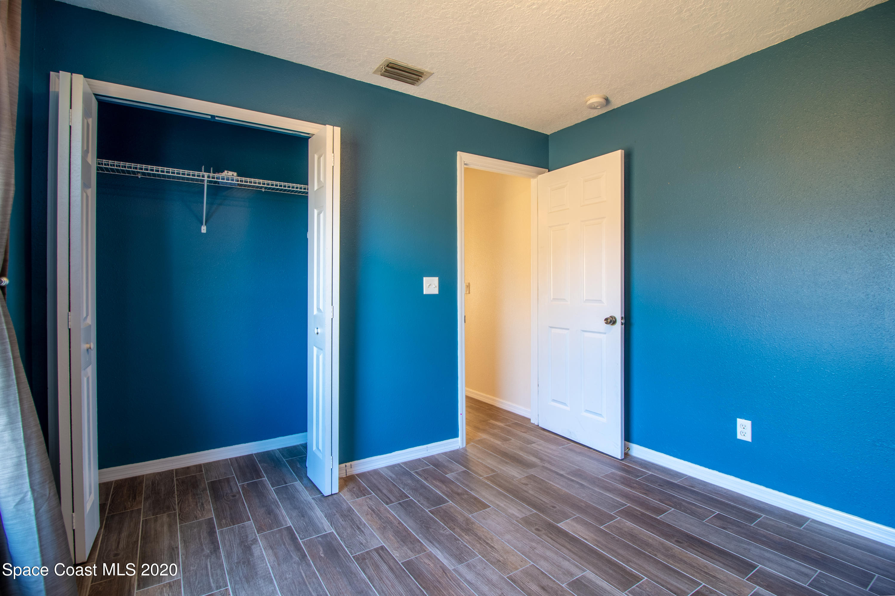 5345 Cangro Street Cocoa, FL 32926 - Photo 21 of 28 an empty room and closet area with wooden floor