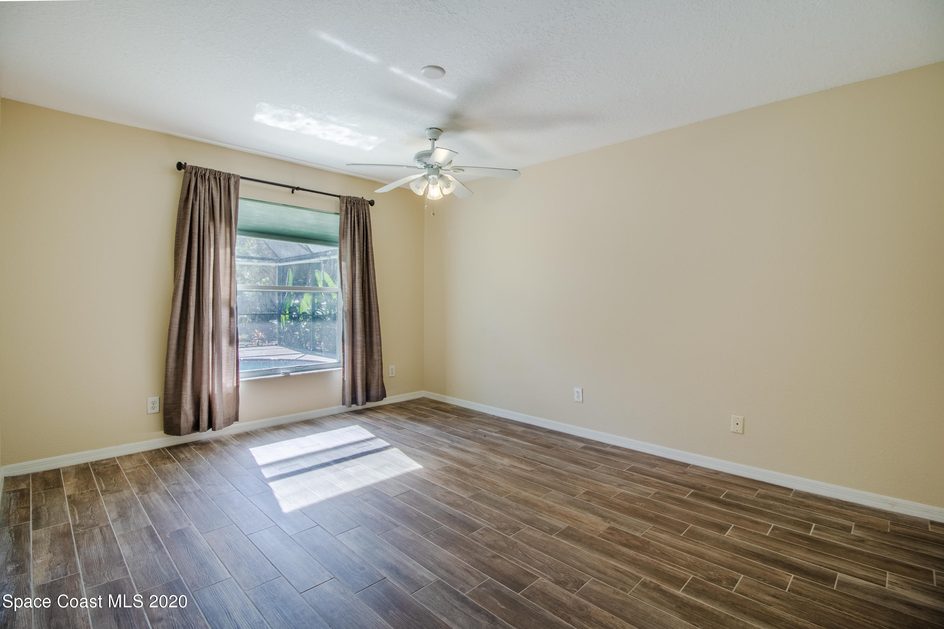 5345 Cangro Street Cocoa, FL 32926 - Photo 22 of 28 an empty room with wooden floor and windows