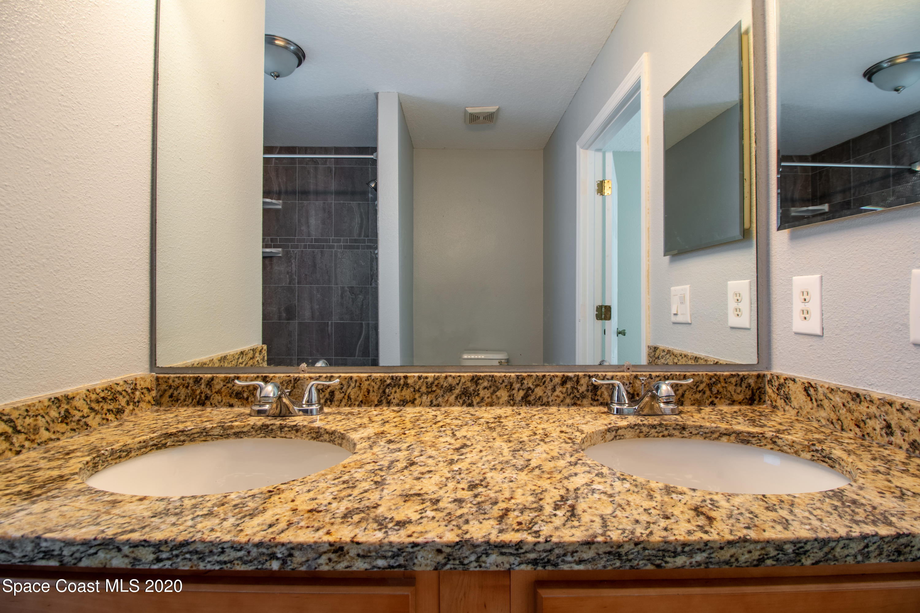 5345 Cangro Street Cocoa, FL 32926 - Photo 24 of 28 a bathroom with a granite countertop sink and a mirror