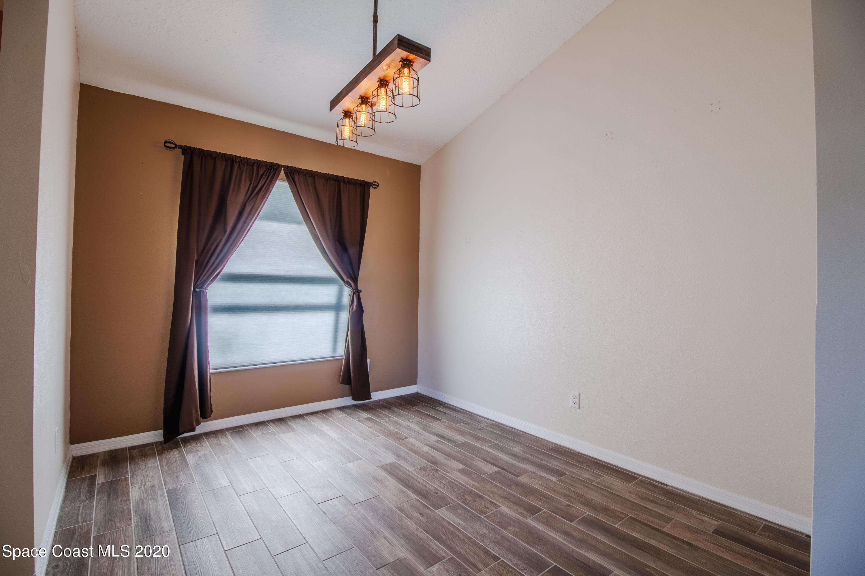 5345 Cangro Street Cocoa, FL 32926 - Photo 8 of 28 an empty room with wooden floor and windows