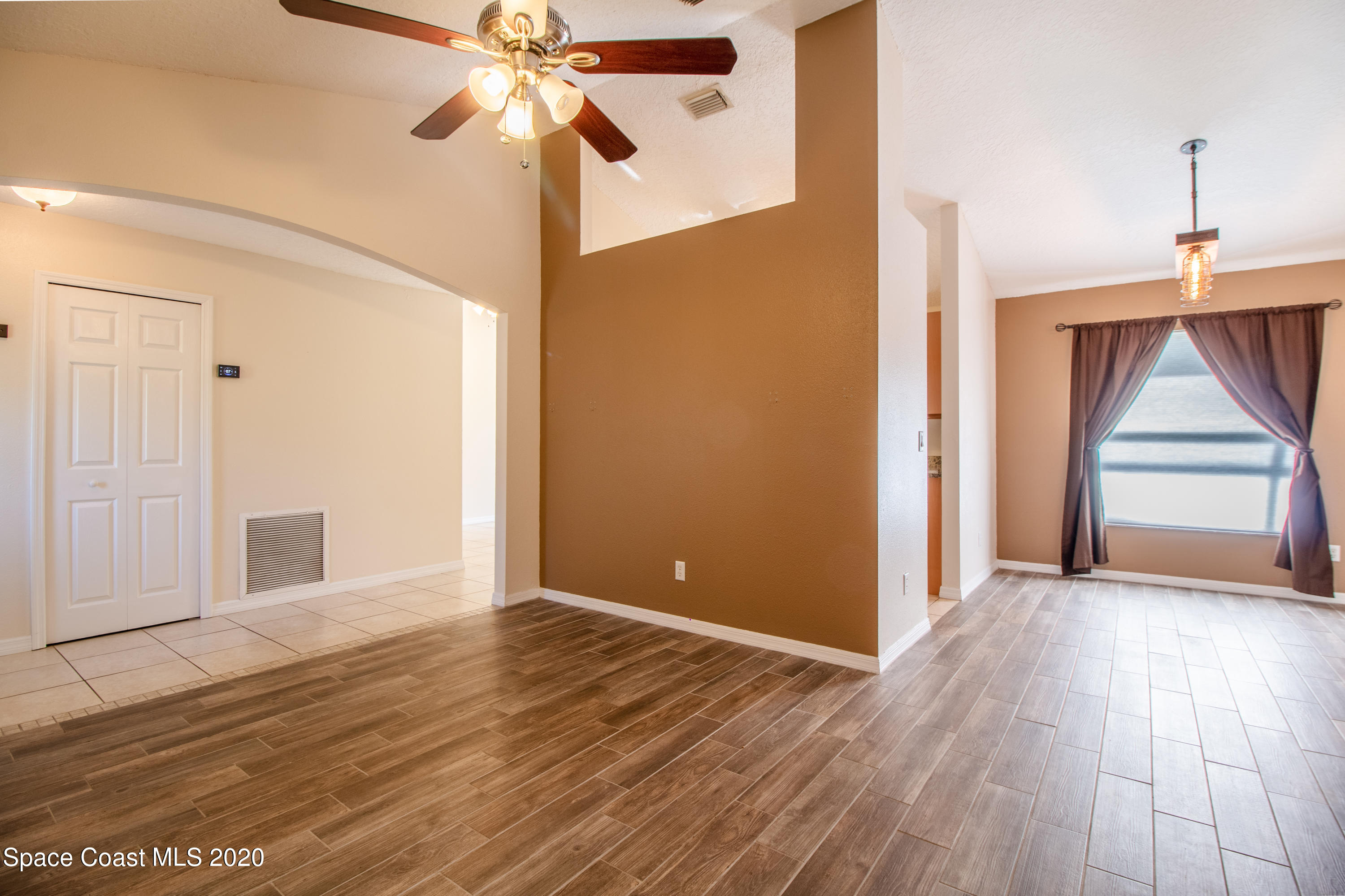 5345 Cangro Street Cocoa, FL 32926 - Photo 9 of 28 a view of empty room with wooden floor and fan
