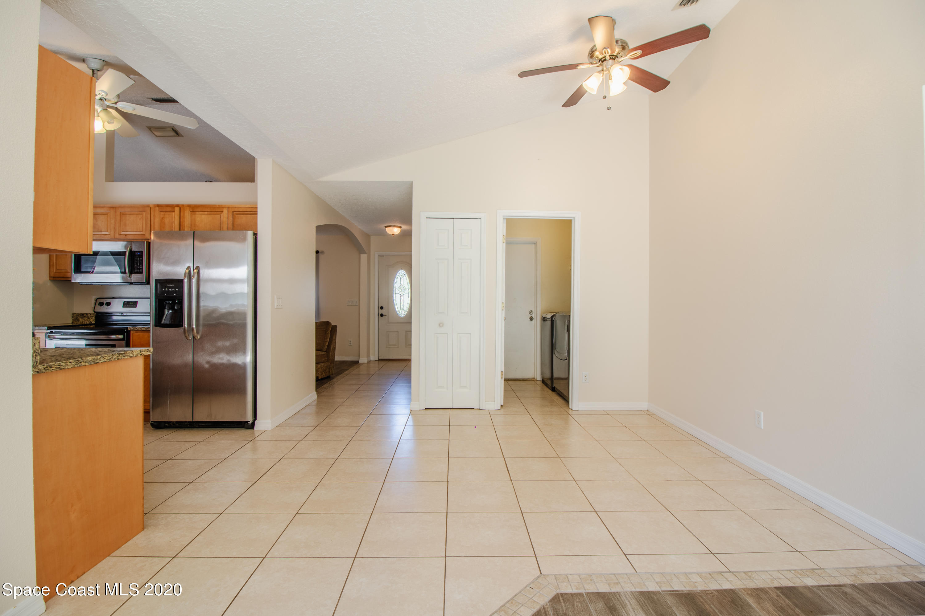 5345 Cangro Street Cocoa, FL 32926 - Photo 10 of 28 a view of a kitchen with a refrigerator and a stove top oven