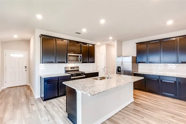 a kitchen with stainless steel appliances granite countertop a sink stove and refrigerator