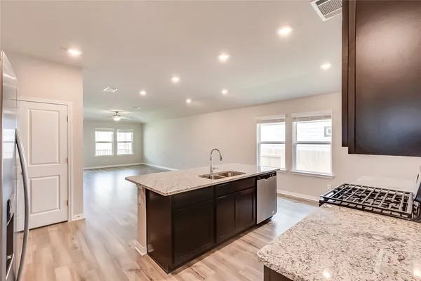 a kitchen with a sink a stove and wooden floor