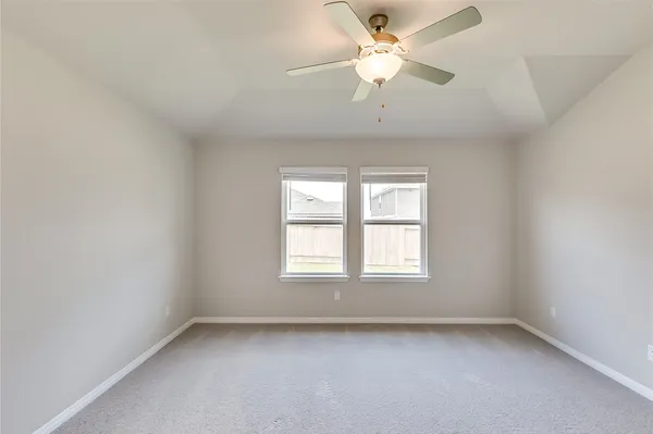 an empty room with a window and a fan