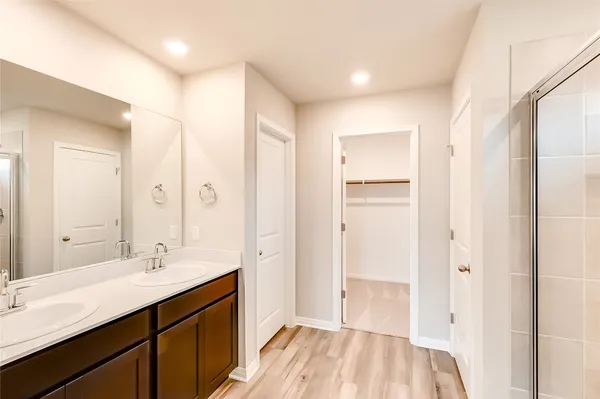 a spacious bathroom with a double vanity sink a mirror and a shower