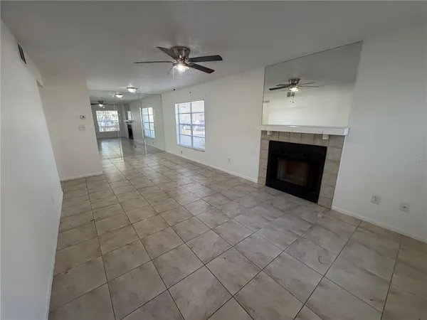 an empty room with windows and fireplace