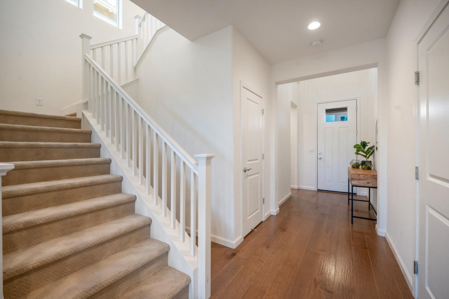 712 Baxter Way Gilroy, CA 95020 - Photo 13 of 37 a view of a hallway with wooden floor and stairs
