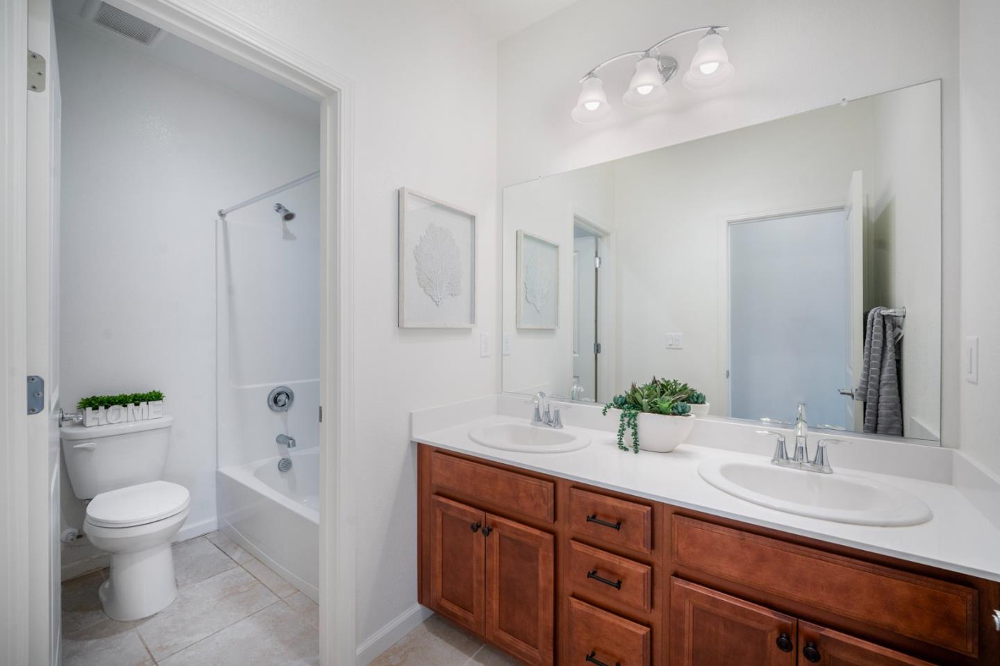 712 Baxter Way Gilroy, CA 95020 - Photo 19 of 37 a bathroom with a granite countertop sink a toilet and a tub