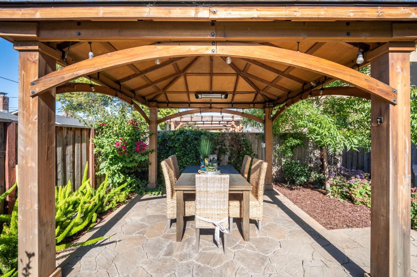 712 Baxter Way Gilroy, CA 95020 - Photo 27 of 37 a view of patio with a table and chairs under an umbrella with a small yard