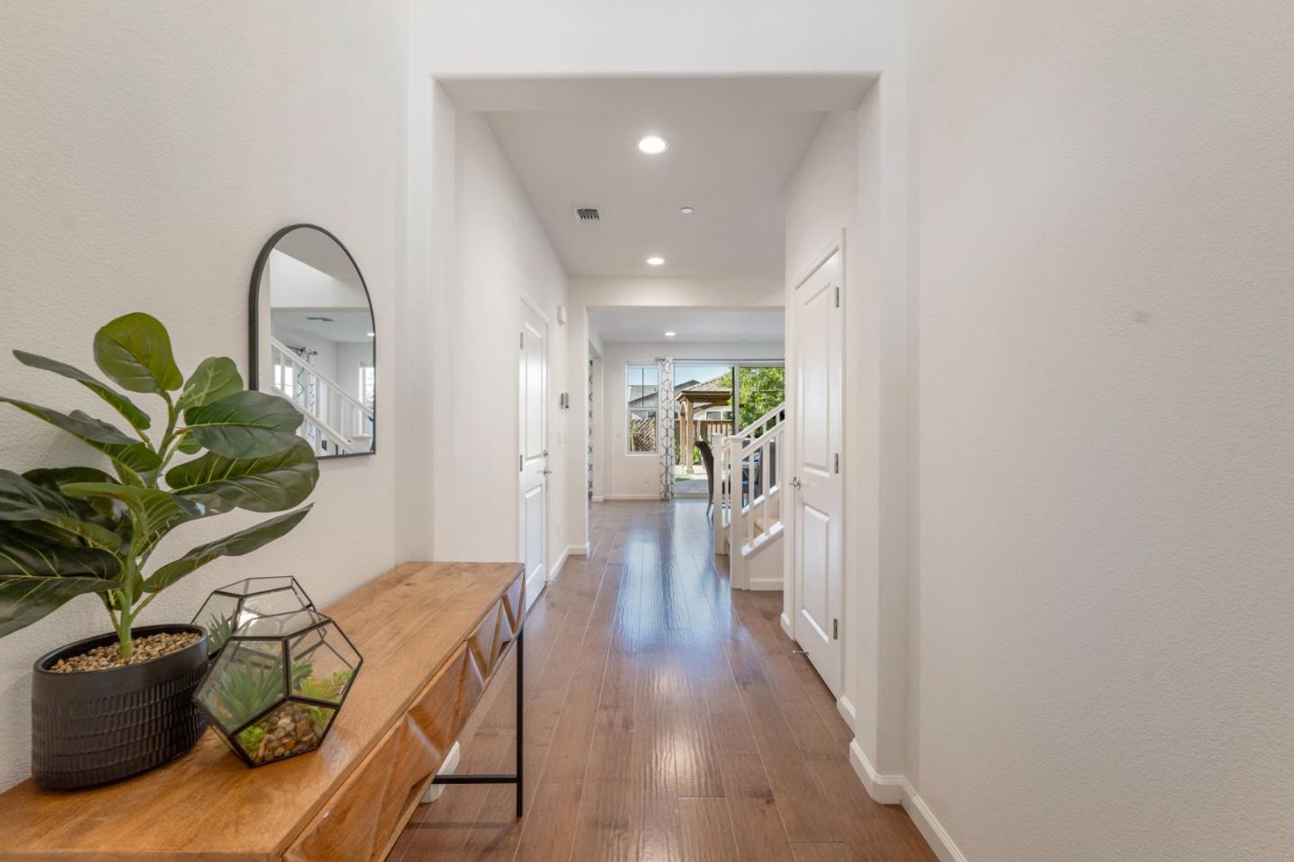 712 Baxter Way Gilroy, CA 95020 - Photo 10 of 37 a view of a hallway with wooden floor and a potted plant