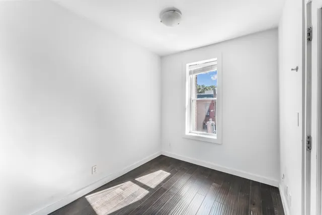 a view of an empty room with wooden floor