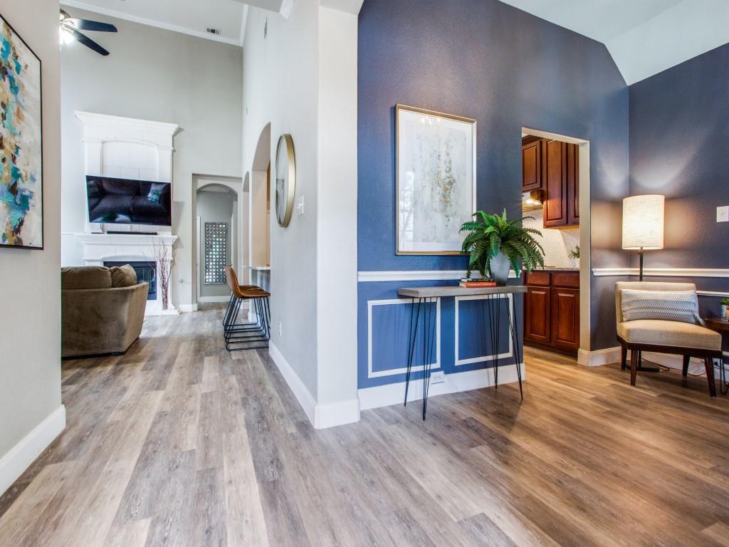 a living room with furniture a flat screen tv and a wooden floor