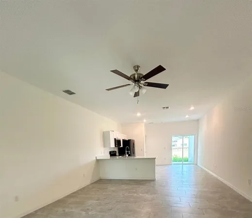 a view of a kitchen with a sink and a ceiling fan
