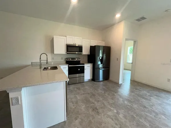 a kitchen with stainless steel appliances a sink stove and refrigerator