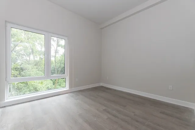 a view of a big room with wooden floor and doors
