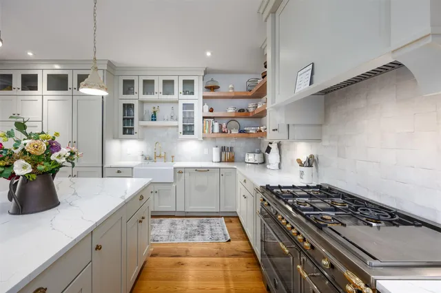 a kitchen with stainless steel appliances granite countertop a sink stove and cabinets