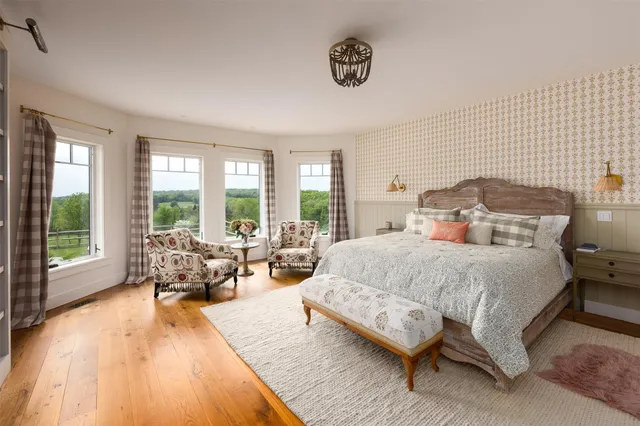 a spacious bedroom with a bed and large windows